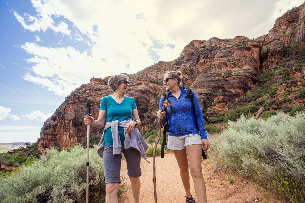 Two,happy,women,hiking,together,in,a,red,rock,sandstone
